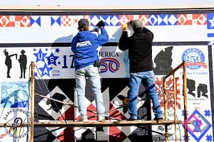 Joe Wintrow (L) of WIntrow Signs installs 250th mural in downtown Greenville. (Gaylen Blosser photo)